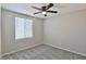 This bedroom includes gray carpet, a lighted ceiling fan, and a window with blinds at 6207 Hamilton Ave, Las Vegas, NV 89122