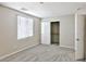 This bedroom features gray carpet, a window with blinds, and an open closet at 6207 Hamilton Ave, Las Vegas, NV 89122