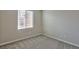 This bedroom includes gray carpet and a window with blinds and neighborhood views at 6207 Hamilton Ave, Las Vegas, NV 89122