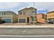 Two-story tan home with a two car garage and manicured front yard featuring easy to care for landscaping at 6207 Hamilton Ave, Las Vegas, NV 89122