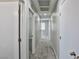 Hallway with grey carpeting and white doors, leading to multiple rooms, and a simple modern design at 6207 Hamilton Ave, Las Vegas, NV 89122