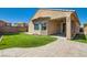 Manicured backyard with artificial turf and brick pavers leading to a covered patio at 6446 Button Quail St, North Las Vegas, NV 89084