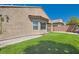 The backyard features easy-to-maintain artificial grass and low brick walls at 6446 Button Quail St, North Las Vegas, NV 89084