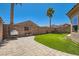 Relaxing backyard with brick pavers, artificial grass, and a hanging chair at 6446 Button Quail St, North Las Vegas, NV 89084