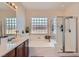 Modern bathroom featuring double sinks, a soaking tub, and a glass-enclosed shower at 6446 Button Quail St, North Las Vegas, NV 89084