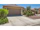 Charming single-story home featuring a two-car garage, desert landscaping, and a tile roof at 6446 Button Quail St, North Las Vegas, NV 89084