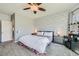 Bright main bedroom featuring brick accent wall, neutral color palette, and plush carpeting at 6446 Button Quail St, North Las Vegas, NV 89084