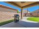 Covered patio area featuring a built-in gas grill and outdoor seating at 6446 Button Quail St, North Las Vegas, NV 89084