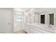 Modern bathroom with dual sinks, a large mirror, and a walk-in shower, exuding elegance and functionality at 66 Via Montoro, Henderson, NV 89015