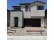 Contemporary two-story home featuring a stone facade, a two-car garage, and neat landscaping at 66 Via Montoro, Henderson, NV 89015