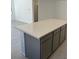 Close-up of kitchen island, displaying gray cabinetry and an impressive quartz countertop at 66 Via Montoro, Henderson, NV 89015