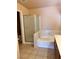 Clean bathroom featuring a walk-in shower and soaking tub with neutral tile at 6600 Silver Penny Ave, Las Vegas, NV 89108