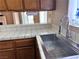 Close-up of a tile countertop and stainless steel sink with a view into the dining room at 6600 Silver Penny Ave, Las Vegas, NV 89108