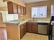 Functional kitchen with tile countertops, wood cabinets, and a view into the dining area at 6600 Silver Penny Ave, Las Vegas, NV 89108