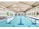 Spacious indoor pool with clear blue water, large windows, and a bright, open atmosphere at 676 Otter Brook St, Henderson, NV 89011