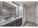 Bathroom boasts dual sinks with dark cabinetry, granite countertops and decorative mirror and lighting at 689 Sea Star St, Henderson, NV 89002