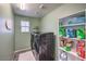 Functional laundry room with modern washer and dryer, shelving, and a window at 689 Sea Star St, Henderson, NV 89002