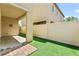 Enclosed backyard featuring a covered patio area and artificial grass for easy maintenance at 7189 Ashcroft St, North Las Vegas, NV 89084