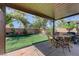 This covered patio overlooks a backyard with artificial grass and mature landscaping at 724 Smokey Mountain Ave, Henderson, NV 89012
