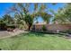 This backyard boasts artificial grass, a brick perimeter, and beautiful mature trees at 724 Smokey Mountain Ave, Henderson, NV 89012