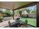 Serene backyard featuring a covered patio, lush green lawn, and mature landscaping at 724 Smokey Mountain Ave, Henderson, NV 89012