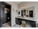 Elegant bathroom with black cabinets, double sinks, a framed mirror and access to the toilet and walk-in closet at 724 Smokey Mountain Ave, Henderson, NV 89012