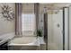 Bright bathroom with a soaking tub, a glass enclosed shower, tile flooring, and a large window at 724 Smokey Mountain Ave, Henderson, NV 89012