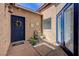 Covered entrance showcasing a unique flower wreath, decorative fountain, and a blue painted door at 724 Smokey Mountain Ave, Henderson, NV 89012