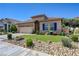 Front exterior showcasing desert landscape, manicured lawn, and charming architectural details at 724 Smokey Mountain Ave, Henderson, NV 89012