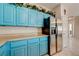 Kitchen with turquoise cabinets, granite countertops and stainless steel refrigerator at 724 Smokey Mountain Ave, Henderson, NV 89012