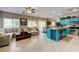 Open floor plan showcases a living room and a kitchen with a bright blue center island and stainless steel appliances at 724 Smokey Mountain Ave, Henderson, NV 89012