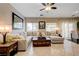 Comfortable living room boasts a large sectional sofa, a ceiling fan, and natural light from the windows at 724 Smokey Mountain Ave, Henderson, NV 89012
