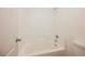 Bright white tiled bathroom with a white tub and shower combo with a shower head at 7316 Childers Ave, Las Vegas, NV 89178