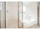 Bright and clean bathroom showcasing a shower with glass door and tub under a window at 7316 Childers Ave, Las Vegas, NV 89178