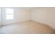 Spacious bedroom with neutral carpet, base trim, and a bright window at 7316 Childers Ave, Las Vegas, NV 89178