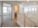 Upstairs hallway featuring white railing, neutral carpet, and multiple doorways to rooms at 7316 Childers Ave, Las Vegas, NV 89178