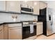 The modern kitchen features stainless steel appliances and grey cabinets and black countertops at 7316 Childers Ave, Las Vegas, NV 89178