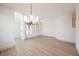 Expansive living space illuminated by a modern chandelier, featuring curved walls and a connecting hallway at 7316 Childers Ave, Las Vegas, NV 89178