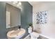 Stylish powder room featuring a modern sink, toilet, elegant mirror, and dark blue accent wall at 7705 Serenity Bay Ln # Lot 57, North Las Vegas, NV 89084