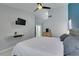 Bright bedroom featuring a ceiling fan, mounted TV, and ensuite bathroom entrance at 8150 Beaverbrook Way, Las Vegas, NV 89123
