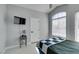 Bright bedroom with window, ceiling fan, mounted television, and hardwood floors at 8150 Beaverbrook Way, Las Vegas, NV 89123