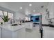 Modern kitchen featuring white cabinets, quartz countertops, stainless steel appliances, and open layout into office at 8150 Beaverbrook Way, Las Vegas, NV 89123