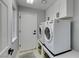 Laundry room with washer, dryer, white cabinets, and gray rug at 8150 Beaverbrook Way, Las Vegas, NV 89123
