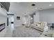 Open-concept living room boasts a fireplace and sleek design with white leather sofas and modern light fixture at 8150 Beaverbrook Way, Las Vegas, NV 89123