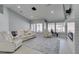 A bright, open living area with white leather sofas, large windows, and modern lighting fixture at 8150 Beaverbrook Way, Las Vegas, NV 89123