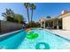 Large swimming pool with tropical landscaping, palm trees and blue skies at 8150 Beaverbrook Way, Las Vegas, NV 89123