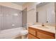 Neutral-toned bathroom features a tiled shower and a vanity with wood-tone cabinets at 8233 Willeta Ave, Las Vegas, NV 89145