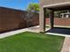 Backyard featuring artificial turf, a covered patio, brick pavers, and a rock bed at 8745 Dodds Canyon St, Las Vegas, NV 89131