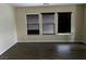 Spacious living room with wood floors and three windows with blinds at 8745 Dodds Canyon St, Las Vegas, NV 89131