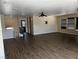 Large living room features modern ceiling fan, dark wood-look flooring and ample natural light from large windows at 8745 Dodds Canyon St, Las Vegas, NV 89131